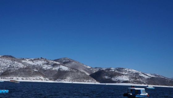 Zlatarsko jezero okruzeno snežnim brdima